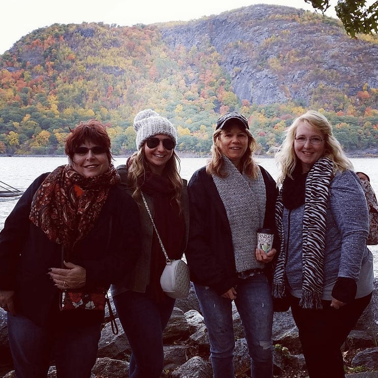 Friends posing for the camera with fall colors in the background