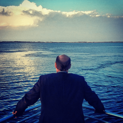 A man looks out over the water from the bow of the ferry