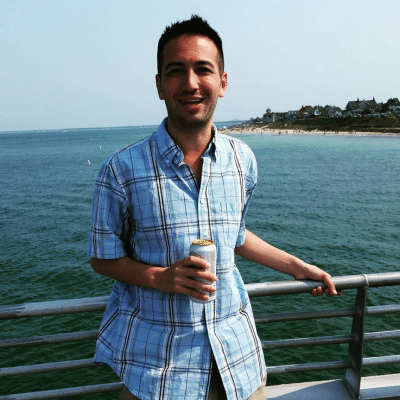 Man on the top deck of the ferry with drink in hand