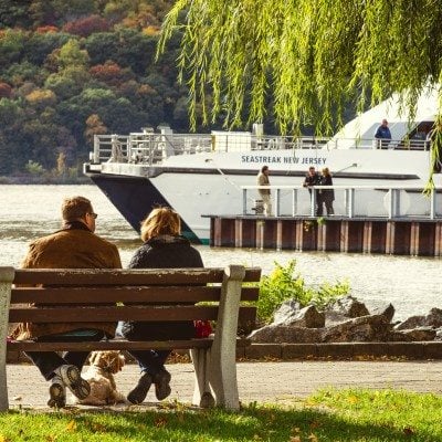 Couple sitting on a bench looking at the ferry