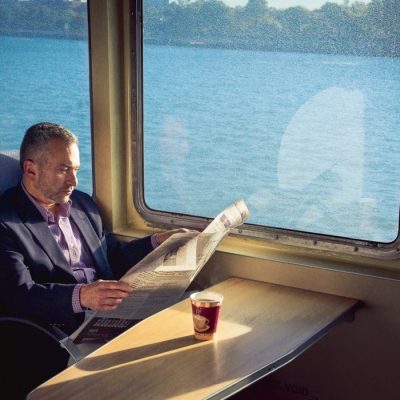 Businessman reading a newspaper on the ferry