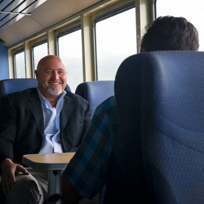 Two businessmen sit around a table on the ferry