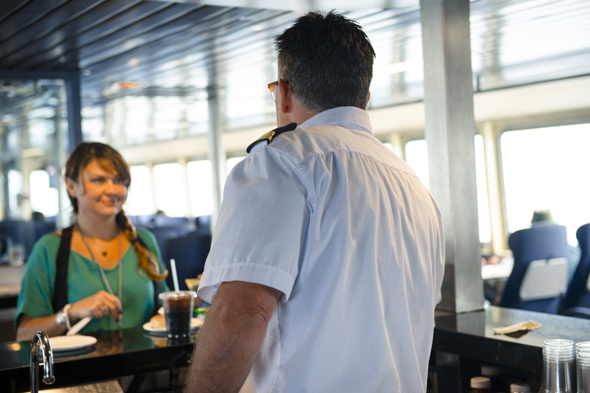A woman orders food and a drink on the ferry