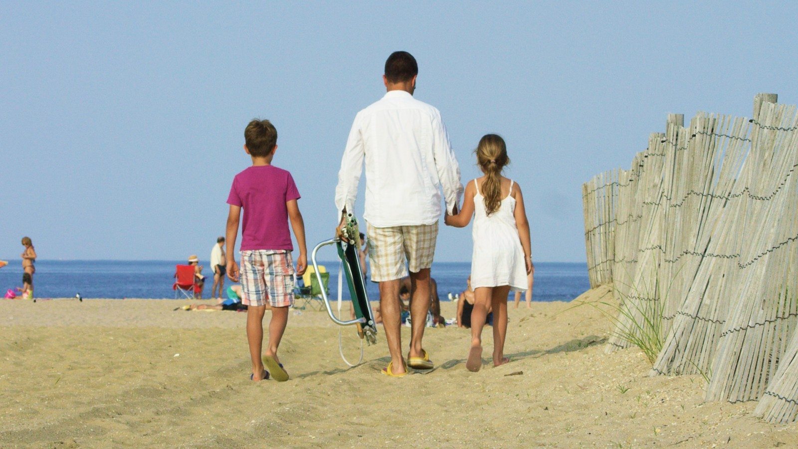 Father and two children headed to the beach.