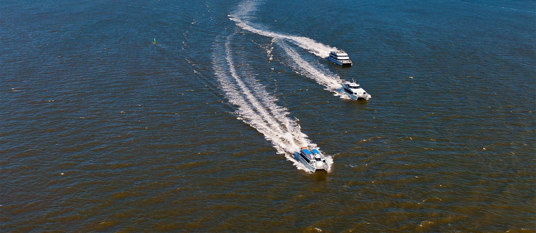 Several Seastreak ferries make their way across the harbor
