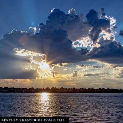 The sun's rays illuminating the clouds over the ocean.