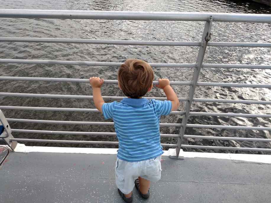 Young child looking out over the water from the ferry